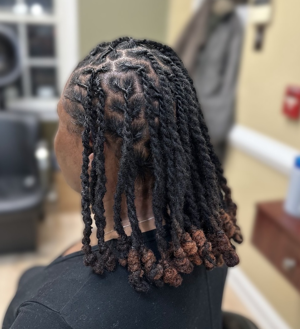 Twisted loc style with copper-toned ends on a client at TEXTURES Hair Salon