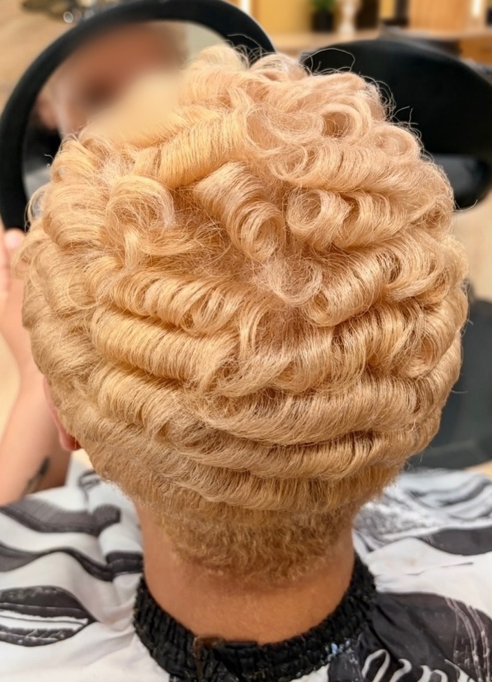Blonde sculpted curls with a tapered nape at TEXTURES Hair Salon
