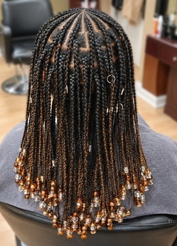 Individual braids finished with gold and clear beads at TEXTURES Hair Salon