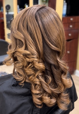Golden highlights and flowing curls at TEXTURES Hair Salon