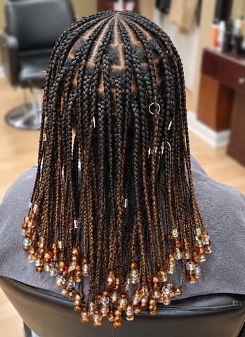 Individual braids with amber and clear beads at TEXTURES Hair Salon