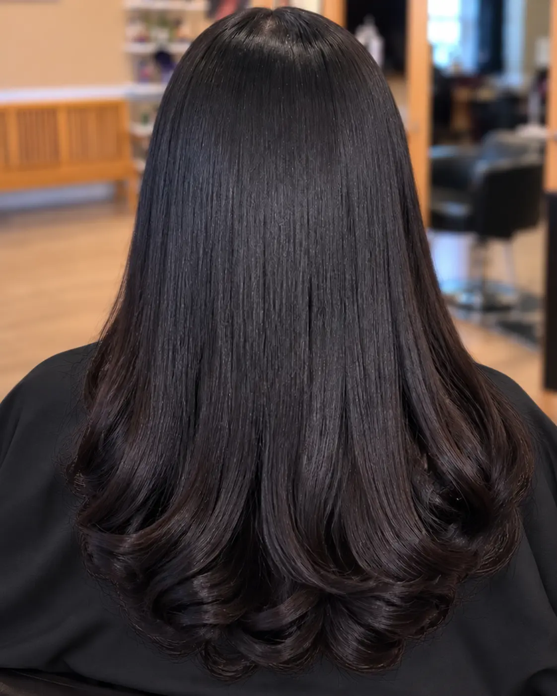 Long dark hair with curled ends at TEXTURES Hair Salon