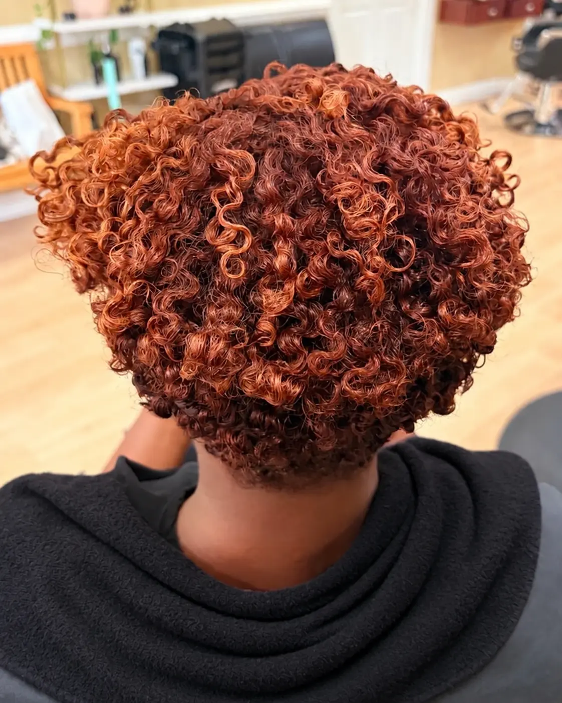 Copper-colored defined curls at TEXTURES Hair Salon