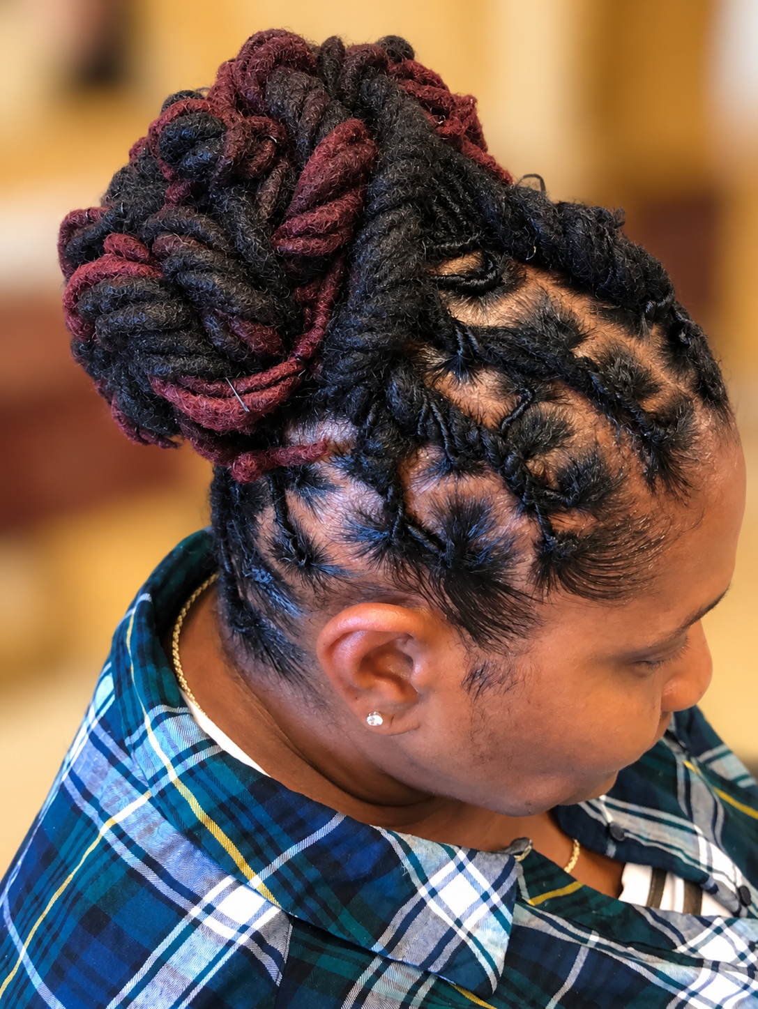 Loc updo with burgundy accents · TEXTURES Hair Salon