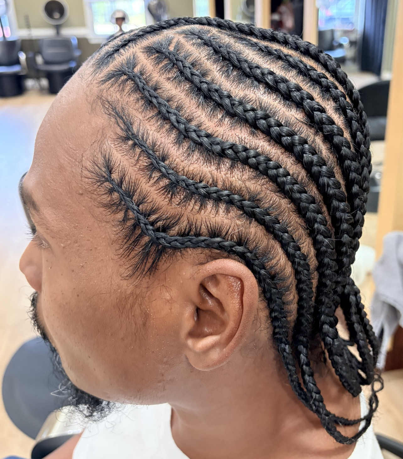 Cornrows with curved parting · side view at TEXTURES Hair Salon