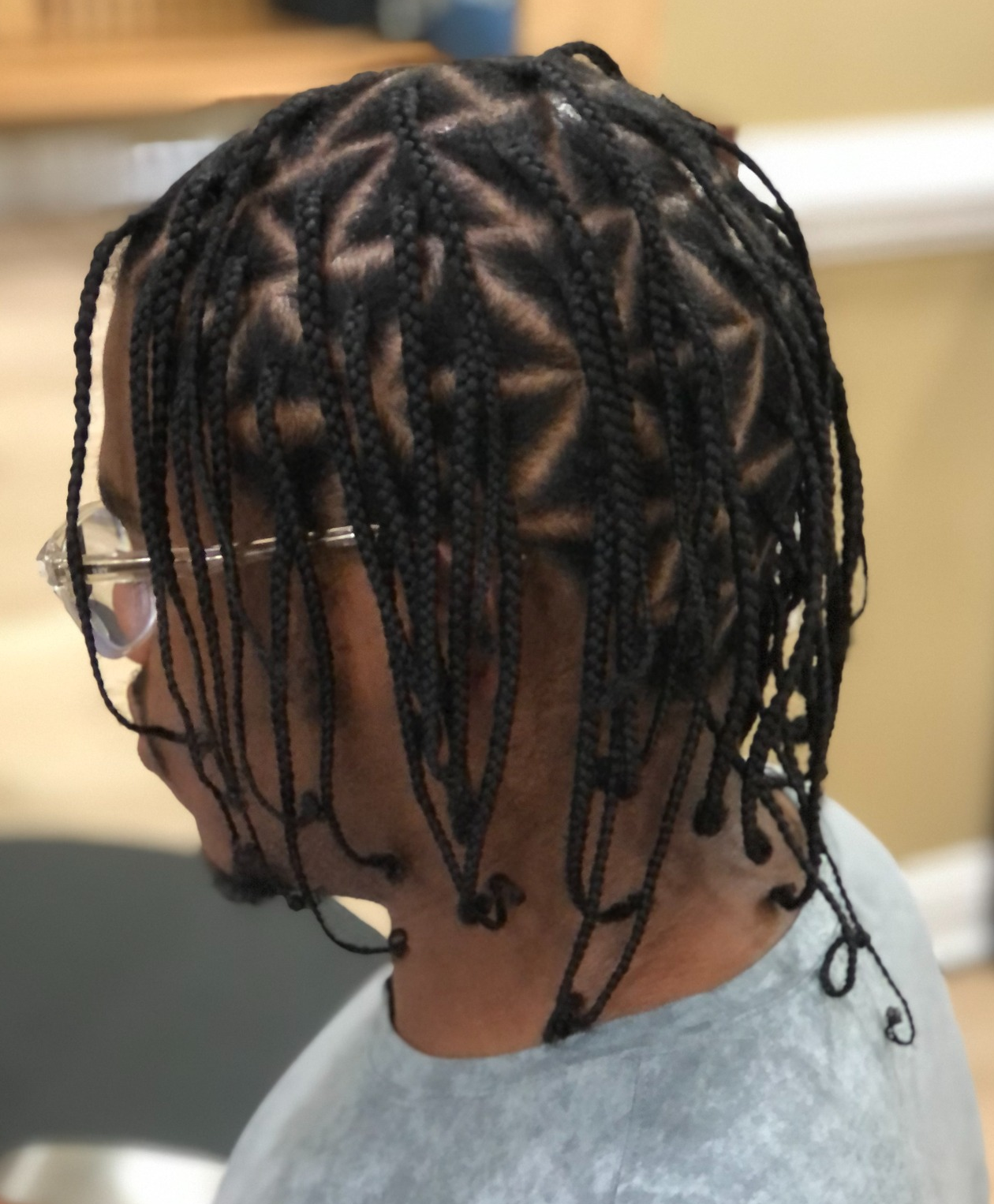 Individual braids with star-shaped parting · back view at TEXTURES Hair Salon