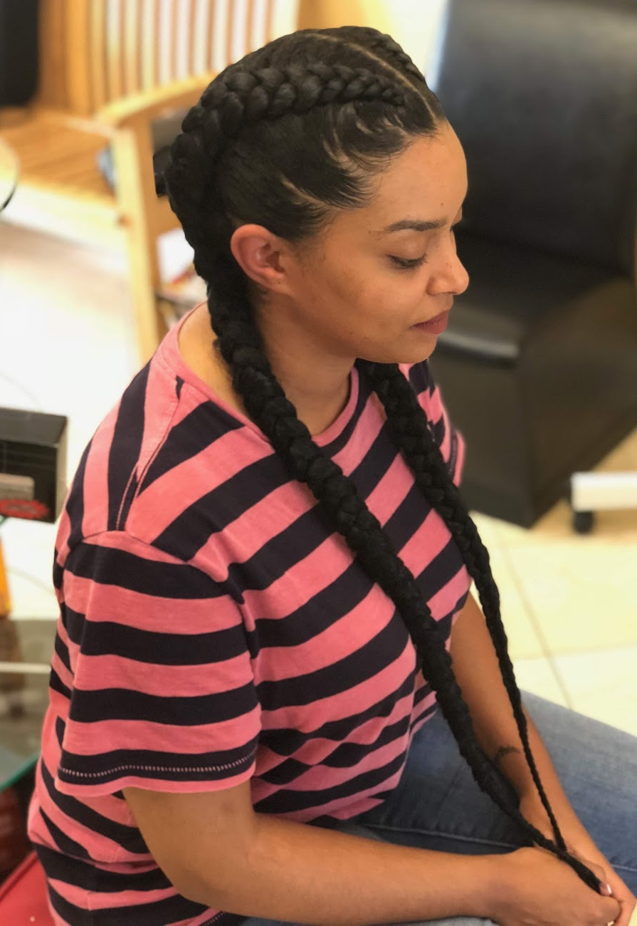 Two long braids with a center part at TEXTURES Hair Salon
