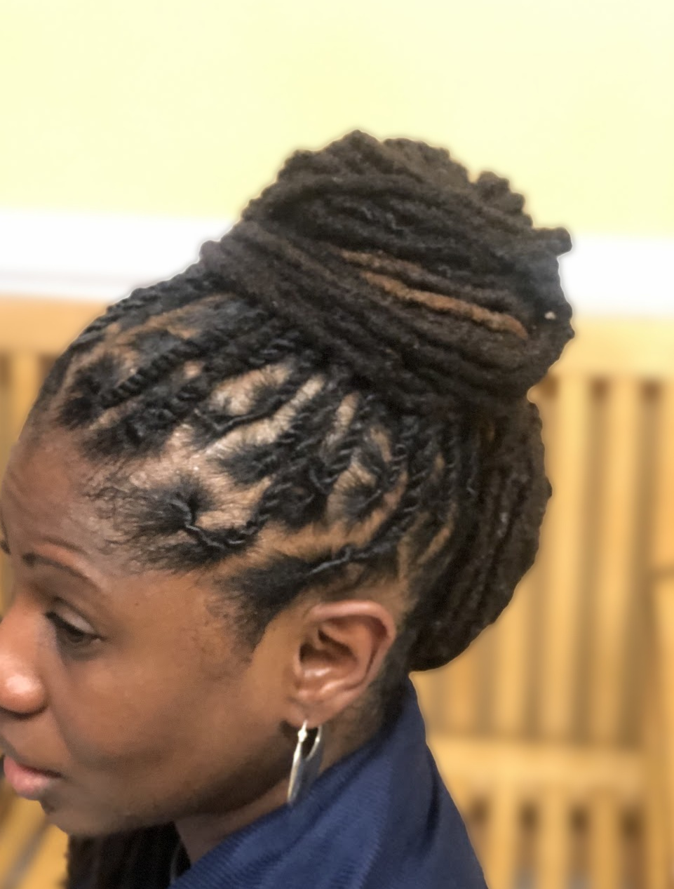 Loc updo with a high bun on a client at TEXTURES Hair Salon
