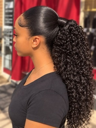 Sleek ponytail with long, defined curls at TEXTURES Hair Salon