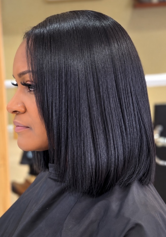 Sleek dark bob with a side part at TEXTURES Hair Salon