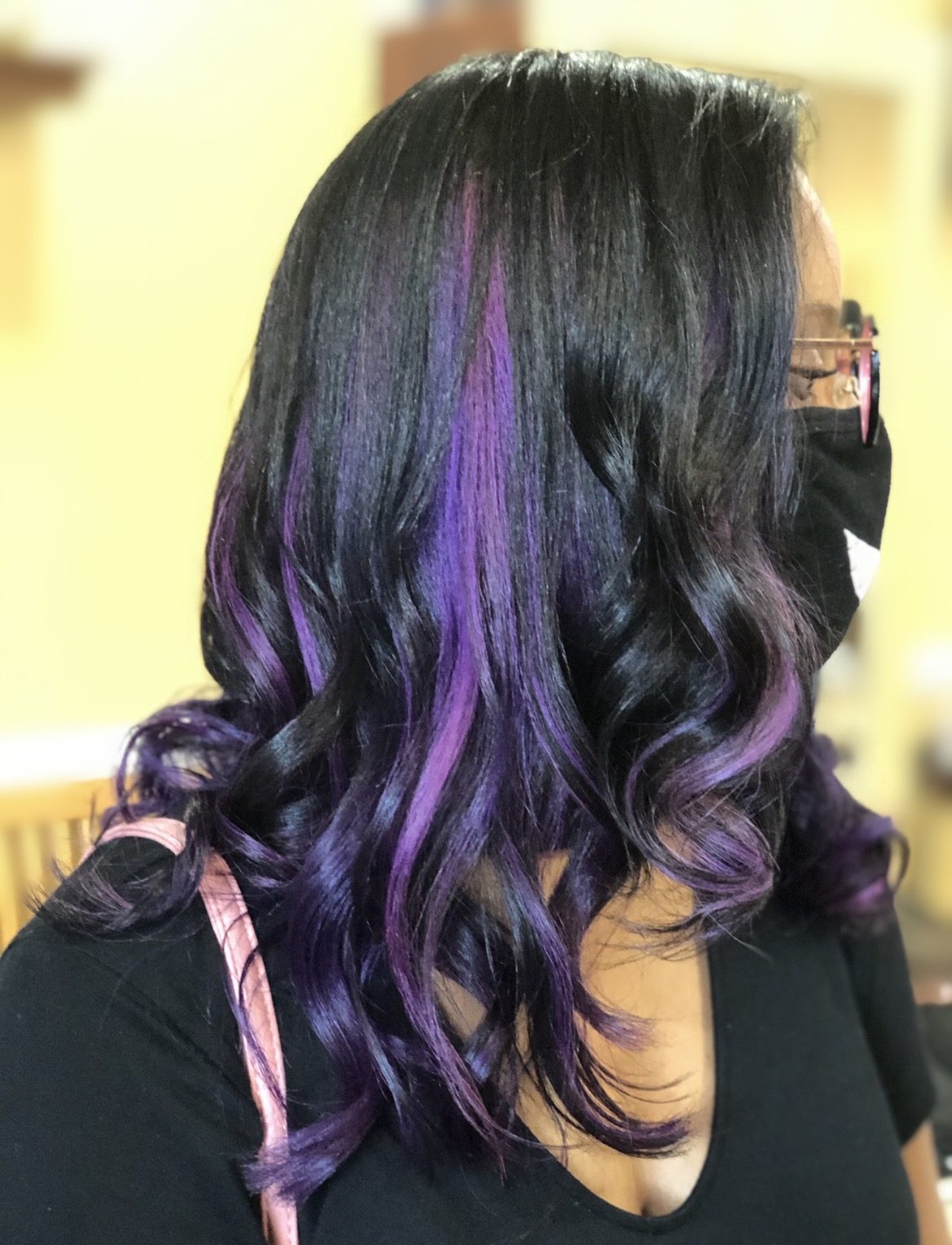 Purple highlights with flowing curls at TEXTURES Hair Salon