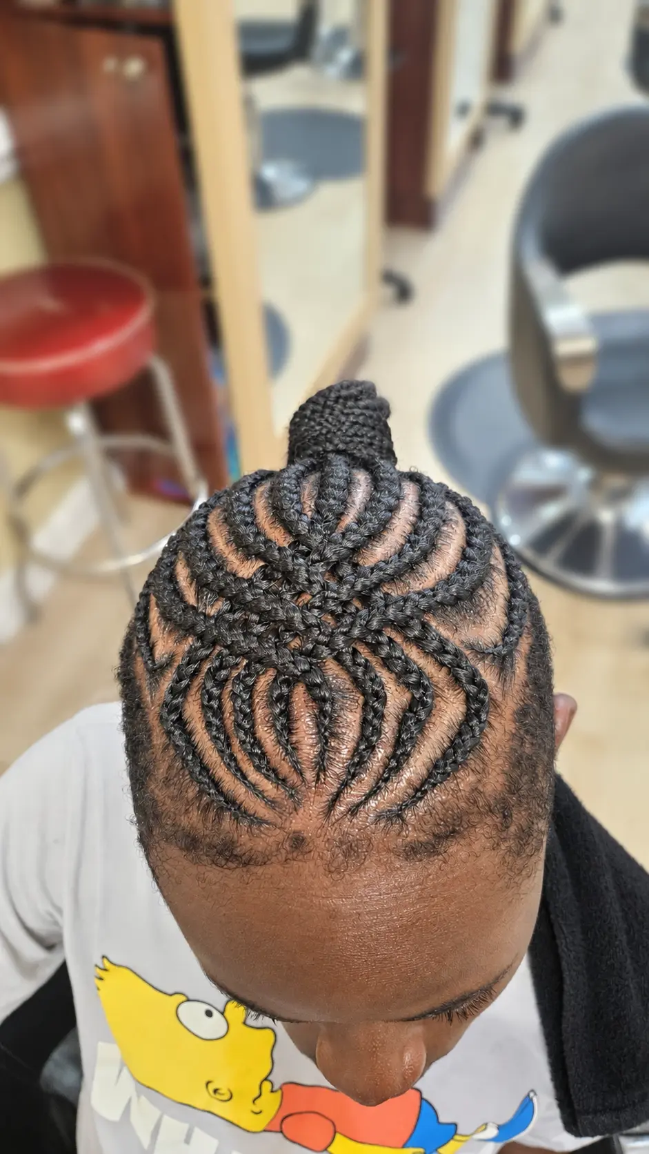 Looped cornrows with a braided bun · top view at TEXTURES Hair Salon