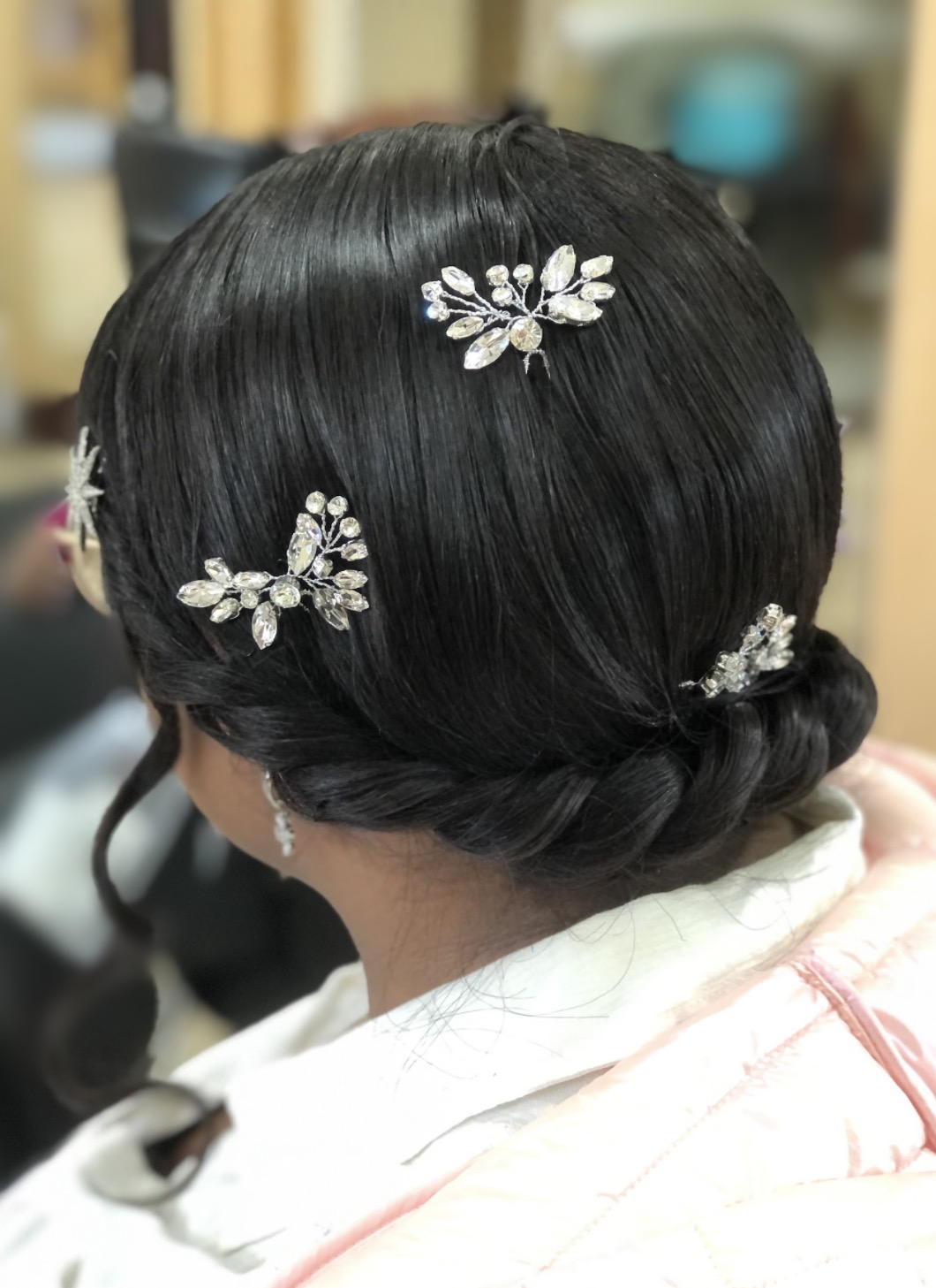 Sleek low updo with jeweled accents at TEXTURES Hair Salon