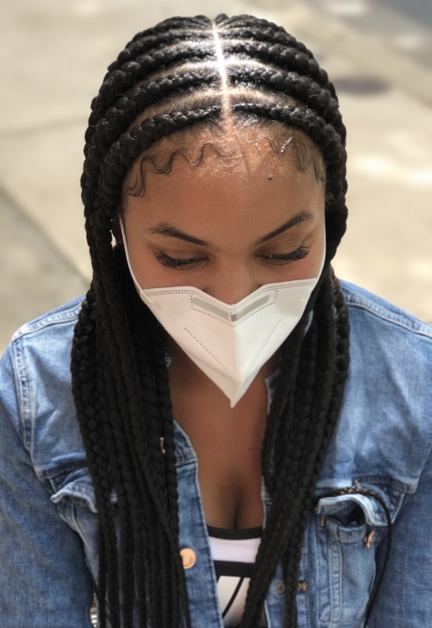 Center-parted cornrows with long braids at TEXTURES Hair Salon